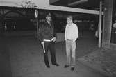 Kvarterspolis Ola Candefors, Batong-Ola kallad, ses tillsammans med en man i Lindome centrum, år 1983.

För mer information om bilden se under tilläggsinformation.