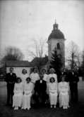 Konfirmander, 8 flickor, 3 pojkar och pastor Persson.
Rinkaby kyrka i bakgrunden.
Pingstdagen 1942.