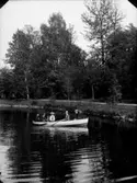 Fem personer i en roddbåt på Svartån.
Stora Holmen i bakgrunden.