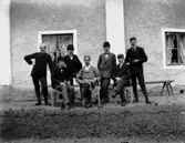 Grupp, sju herrar.
Bostadshus i bakgrunden.