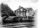 Bostadshus med trädgård.En man framför huset.Järnväg i förgrunden.