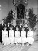 Nio konfirmander, fem flickor, fyra pojkar och kyrkoherde Erhard Morén.
Interiör av Vintrosa kyrka.