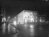Stadsvy, Drottninggatan söderut, bostadshus med affärer i gatuplanet.
Örebro Sparbank till höger på bilden.
Bilden tagen på natten.