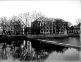 Karolinska läroverket, trevånings skolbyggnad.
Olaigatan med bostadshus.
Svartån i förgrunden.