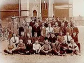 Norra Folkskolan, 35 skolpojkar med lärare, sal 27. Skolbyggnad i bakgrunden.
E.G. Mollbeck
