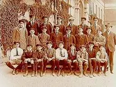Norra Folkskolan, Högre Folkskolan eller Fortsättningsskolan, 23 skolpojkar med lärare, sal 37. Skolbyggnad i bakgrunden.
K.G. Stenkvist