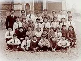 Norra Folkskolan, 30 skolpojkar med lärare, sal 20. Skolbyggnad i bakgrunden.
E. Björling