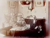 Rumsinteriör, en man i soffan.Almström på 50 årsdagen.