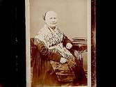 En äldre kvinna i folkdräkt.Beställare: Leonard Larsson.