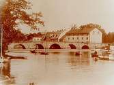 Kanslibron. I bakgrunden gamla husarstallet och Arbetshuset, ångslupar i ån.
 Originalbilden tagen omkring 1894, reproduktion 1929.