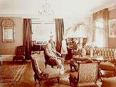 Rumsinteriör, familjegrupp 5 personer.Grosshandlare Oskar C. Johansson