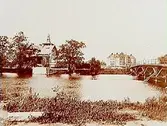 Hagabron, gamla träbron över Svartån. Vasaskolan, trevånings skolbyggnad i tegel. Trähus i tre våningar, villa i jugendstil.
OBS! Badhuset vid ån. Hertig Karls Allé västerut.
Reproduktion efter en bild tagen 1903.