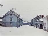 Tvåvånings bostadshus.
Drottninggatan norrut från Änggatan.
Reproduktion (1934) efter en bild från januari 1919.