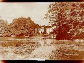 Vissboda gård, tvåvånings bostadshus med frontespis, vid sjön.Bilden tagen efter vykort.