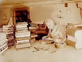 Interiör av bokbinderi, en man i arbete.
Bokbindare Karl Ek.