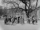 Oskarsparken, lekplatsen med två gungor, lekande barn.