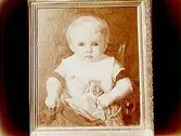 Oljemålning.
Konstnär: Den finländske målaren Albert Edelfelt.
Motiv: Barnporträtt föreställande Maria Lindholms avlidne man, Ragnar Lindholm vid två års ålder, 1875.
Fru Maria Lindholm, Viktoriagatan 22, Örebro.