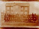 Järna folkskolan, tvåvånings timmrad skolbyggnad med trapphus. 30 skolbarn med lärare framför skolbyggnaden. Järna sockens första och vid den tiden enda folkskola. Originalfotot är taget 1872. Reprobild.
Beställare: fru Tonner, Oskarsplatsen 1, Örebro.