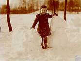 En liten flicka rullar snöbollar.
Bankkamrer Georg Falander
