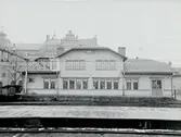 Järnvägsstationen, envånings magasinbyggnad med inredd vind ilgodsmagasinet.
Statens Järnvägar.