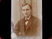 En man, bröstbild, fru Karlssons fader.
Köpman Gustaf Karlsson, Örebro Exportaffär.