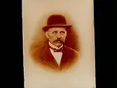 En äldre man med hatt, bröstbild. 
Beställare: fru Ester Karlsson