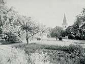 Envånings skolbyggnad i förgrunden.
Askers kyrka i bakgrunden.