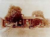 Tvåvånings bostadshus, två hästar och ett föl framför huset, västra gården.
Bilden tagen efter ett blekt kort (År 1836-1945).
