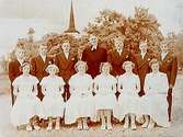 Hovsta kyrka i bakgrunden.
12 konfirmander, 6 flickor, 6 pojkar med pastor Ljunggren.
Pingstafton den 27 maj 1950.