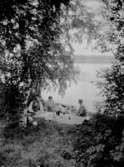 Fyra personer vid sjön Viker, kaffedrickande i gröngräset.
Utsikt över sjön.