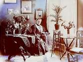 Rumsinteriör, en kvinna i soffan.Ingenjör J.E. Zetterlund