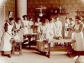 Lärare under slöjdundervisning, 11 unga damer.
Kindergarten.