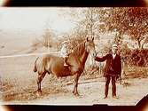 En man med häst med en liten pojke på ryggen.
Uno Sörman