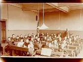 Klassrumsinteriör, 40 skolbarn.
Folkskollärare K.J. Englund.