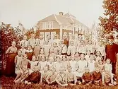 Talby skola, en och en halvplans skolbyggnad med frontespisar, balkong, brutet tak i tegel
45 skolbarn med lärare Witalis Jansson.