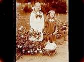 Två småflickor, den ena med dockvagn med två dockor i.
Gustaf Eriksson