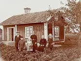 Envånings bostadshus.Familj 6 personer framför huset.G. Alm.