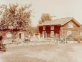 Tvåvånings enkelstuga i liggtimmer.
Envånings enkelstuga i liggtimmer.
10 personer framför huset.
Anders Olsson.