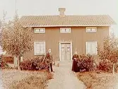 En och en halvvånings bostadshus.
Äldre par framför huset.
C.J. Rosell
