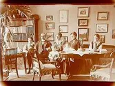Rumsinteriör, familjegrupp 7 personer.
Folkskollärare V. Dahl