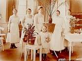 Länslasarettet, interiör, fem sköterskor och en liten patient.
Syster Karin Ungerth