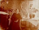 Rumsinteriör, en kvinna.Änkefru Anna Andersson på 70 årsdagen.