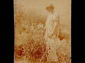 En kvinna bland blommor.
Astrid Vall