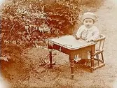 Sonen Erik i barnstol i trädgården.
Fjärdingsman Edvard Medin