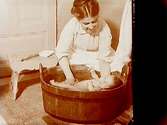 Familjebild, badning av sju veckors barn.
Märta Lindskog, 7 veckor gammal. (Märta var född 1906-09-12).
Sam Lindskogs privata bilder.
Två bilder (8x8 cm) på samma glasplåt (8x17 cm).