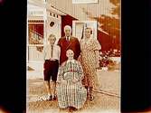 Bostadshus, fyra personer framför huset.Sam Lindskogs familjebild.