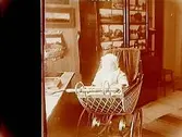 Ett barn i barnvagn.Sam Lindskogs familjebild.Två bilder på samma glasplåt.