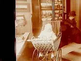 En dam, ett barn i barnvagn.Sam Lindskogs familjebild.Två bilder på samma glasplåt.