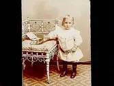 Ett litet barn vid en stol.Ernst Pettersson