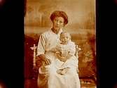 En kvinna med ett barn på armen.
Fröken Svea Svedberg
